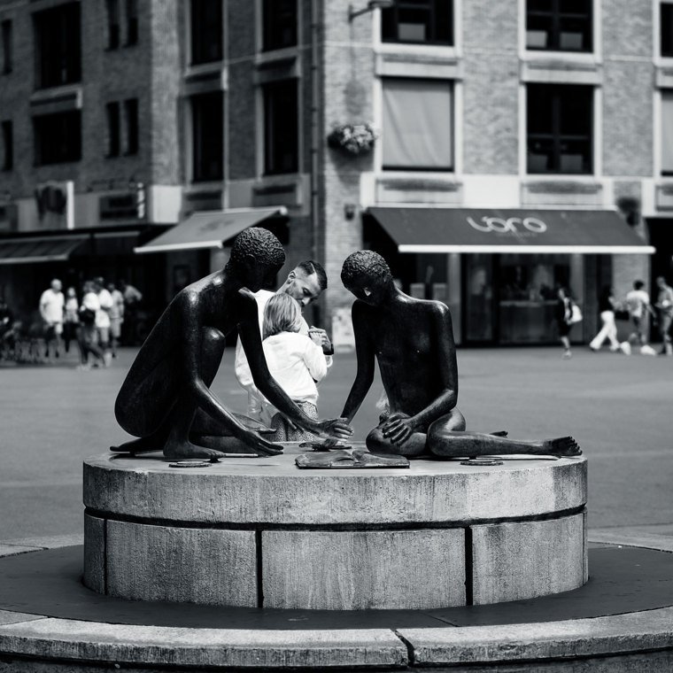 Deux personnes penchées au bord d’une fontaine