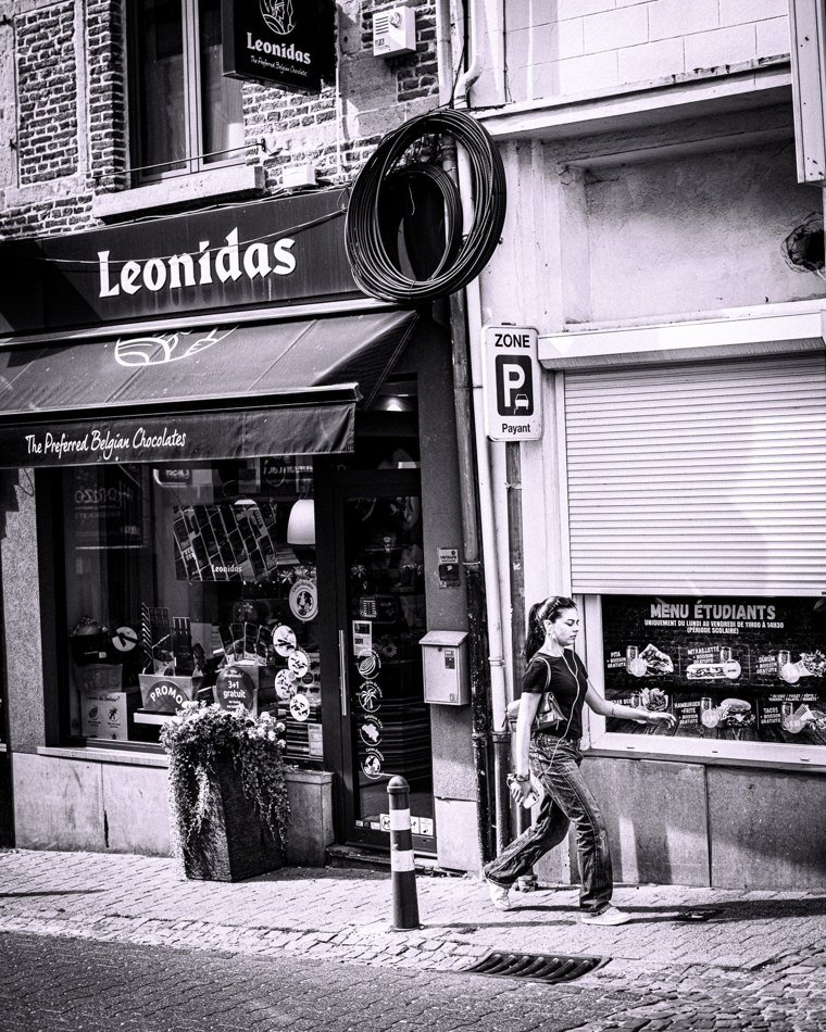 Passante devant une vitrine et une enseigne urbaine