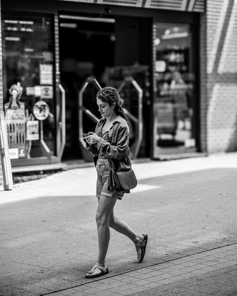 Passante traversant la lumière devant une boutique